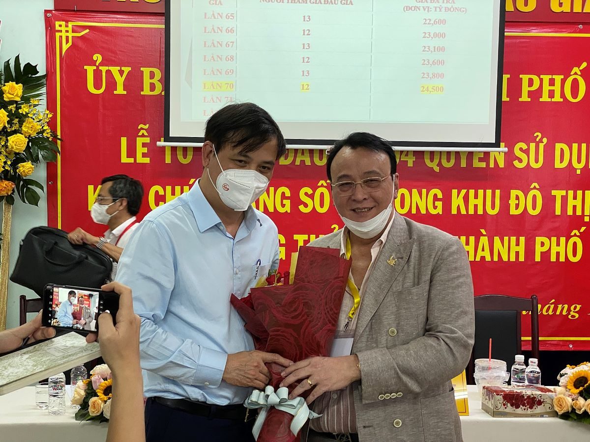 Ông Lê Hoà Bình phó chủ tịch UBND Thành phố Hồ Chí Minh chụp ảnh lưu niệm cùng đại diện Công ty TNHH Đầu tư Bất động sản Ngôi Sao Việt đơn vị trúng đấu giá lô đất 3-12.